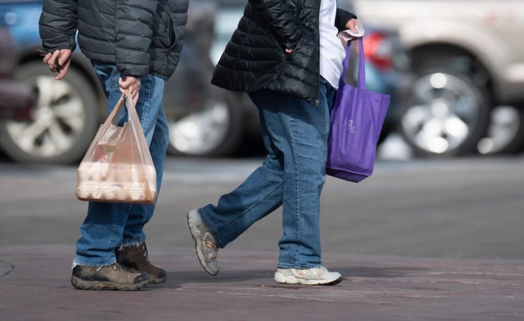 customers，one carrying plastic bag another carrying reusable bag